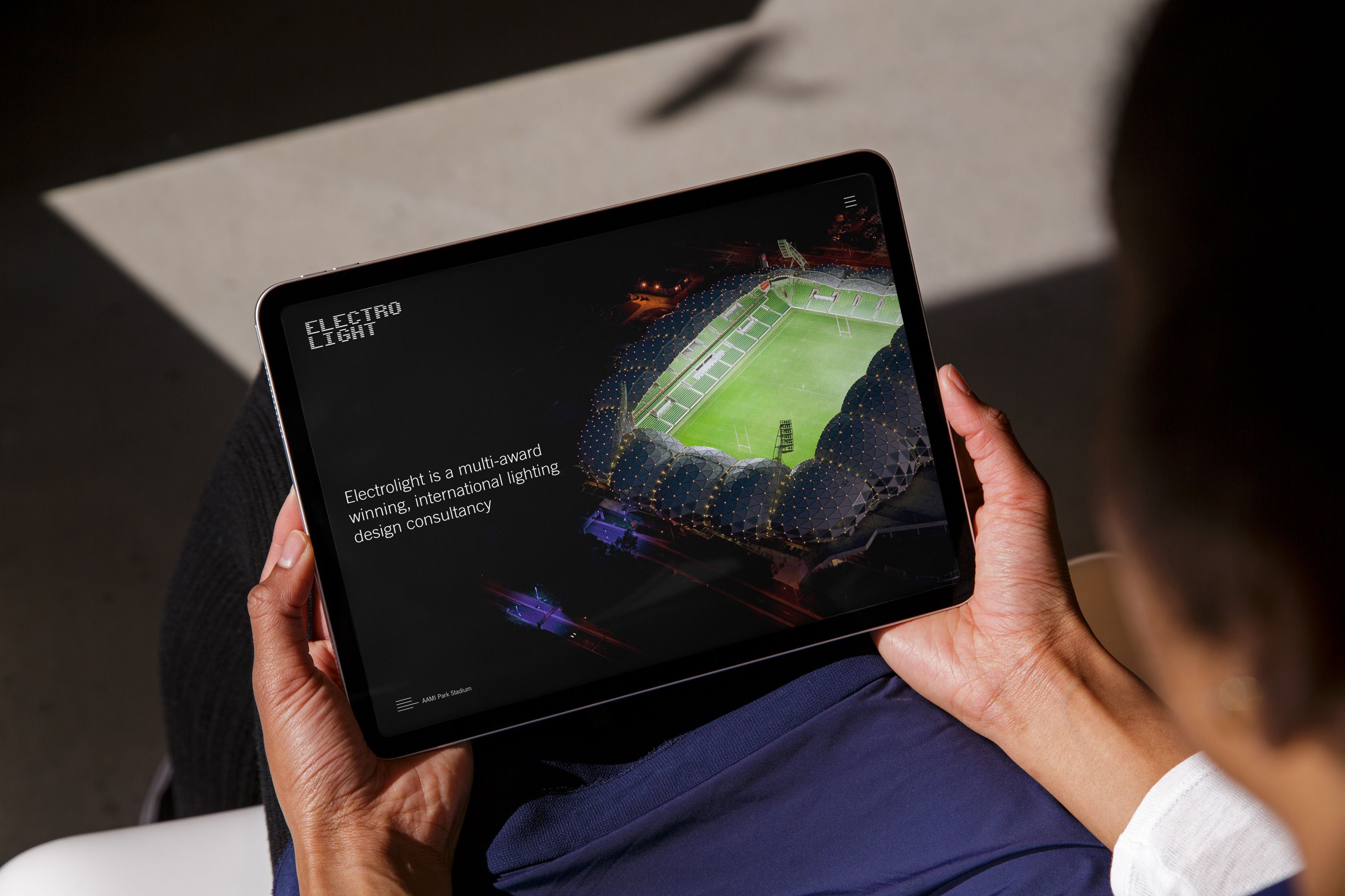 Someone holding an iPad showing the electrolight website.