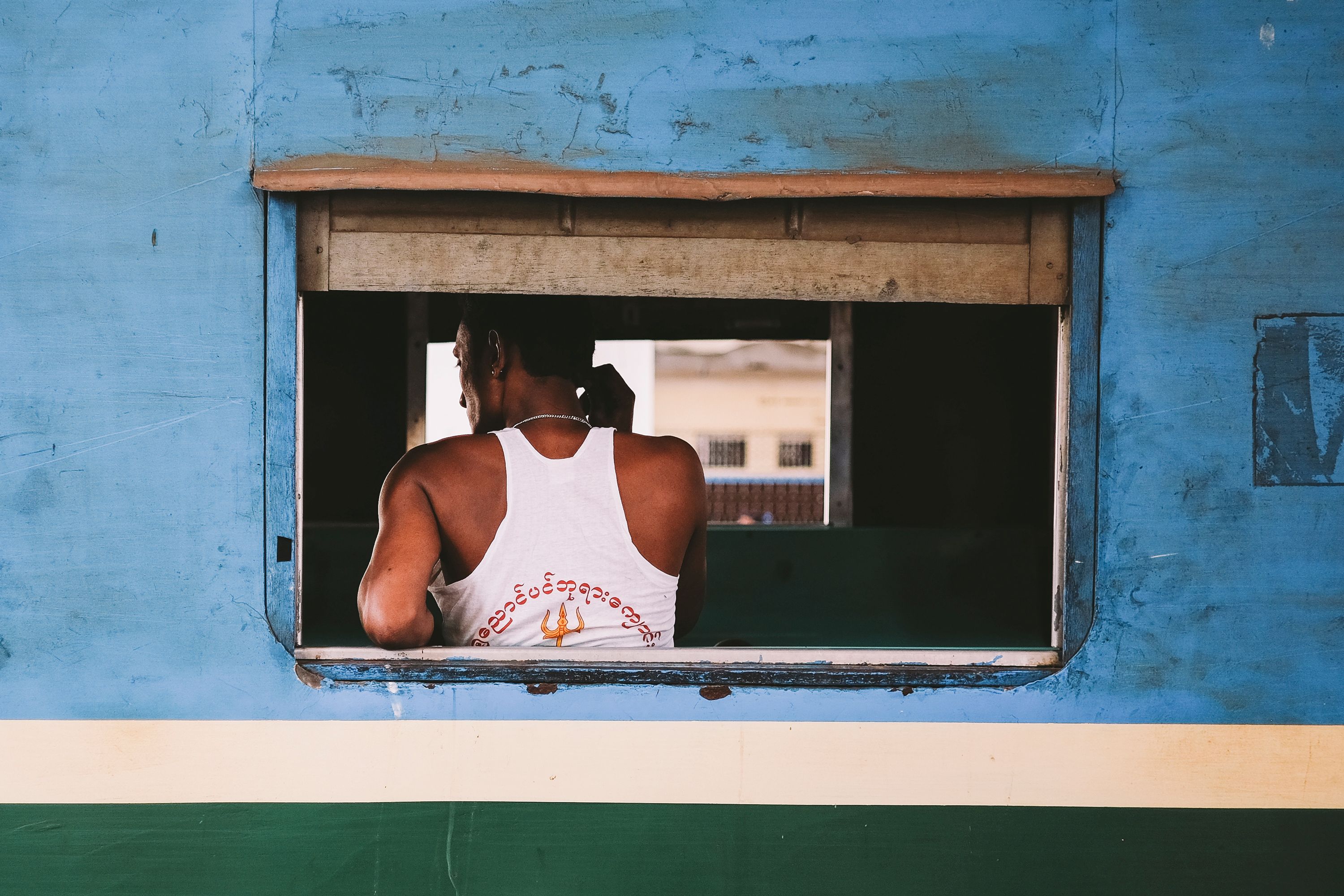 A photograph from Boat Magazine. A woman observes the passing scenery through a train window, lost in her thoughts.