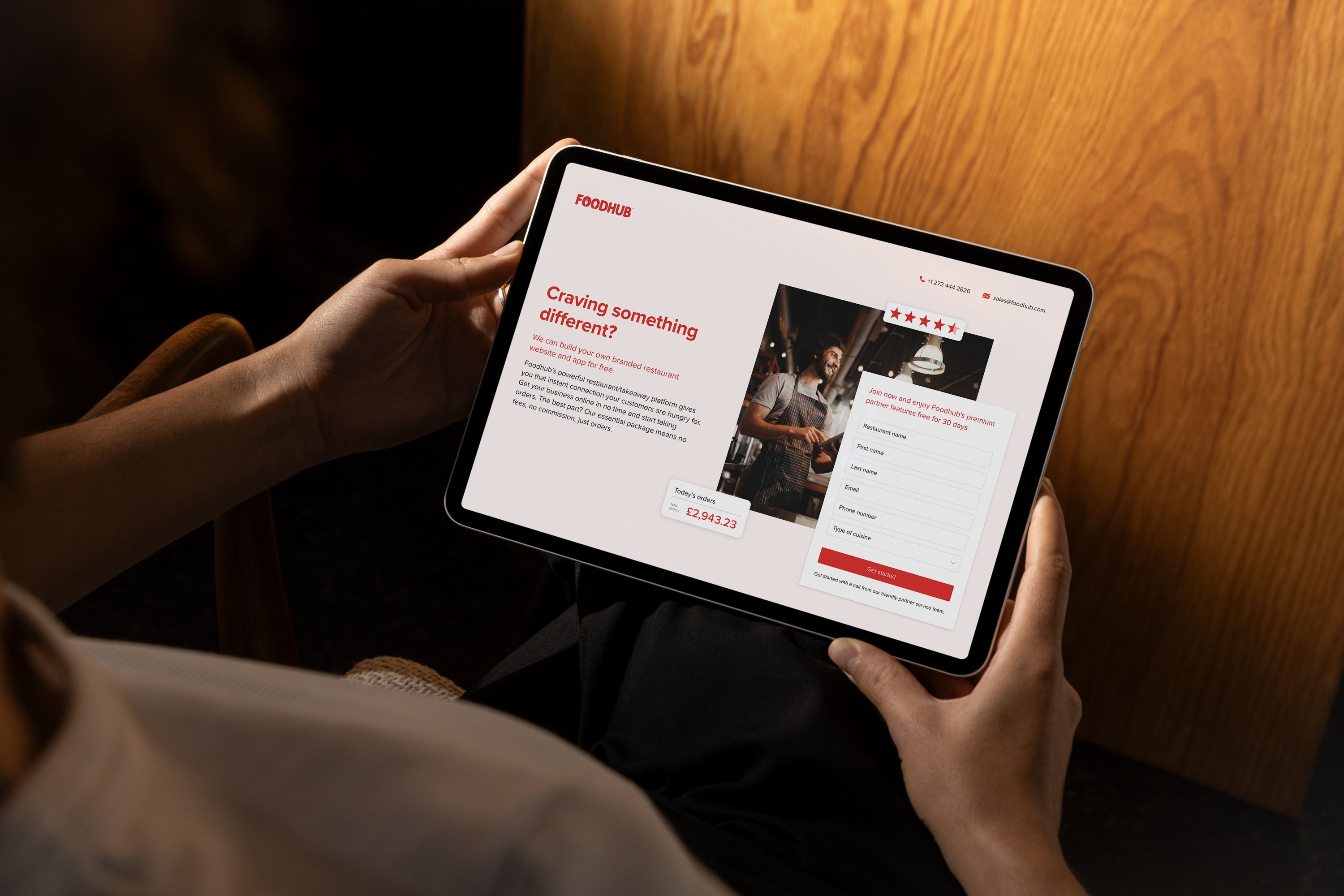 Someone using a tablet, browsing a the Foodhub landing page with focused interest.
